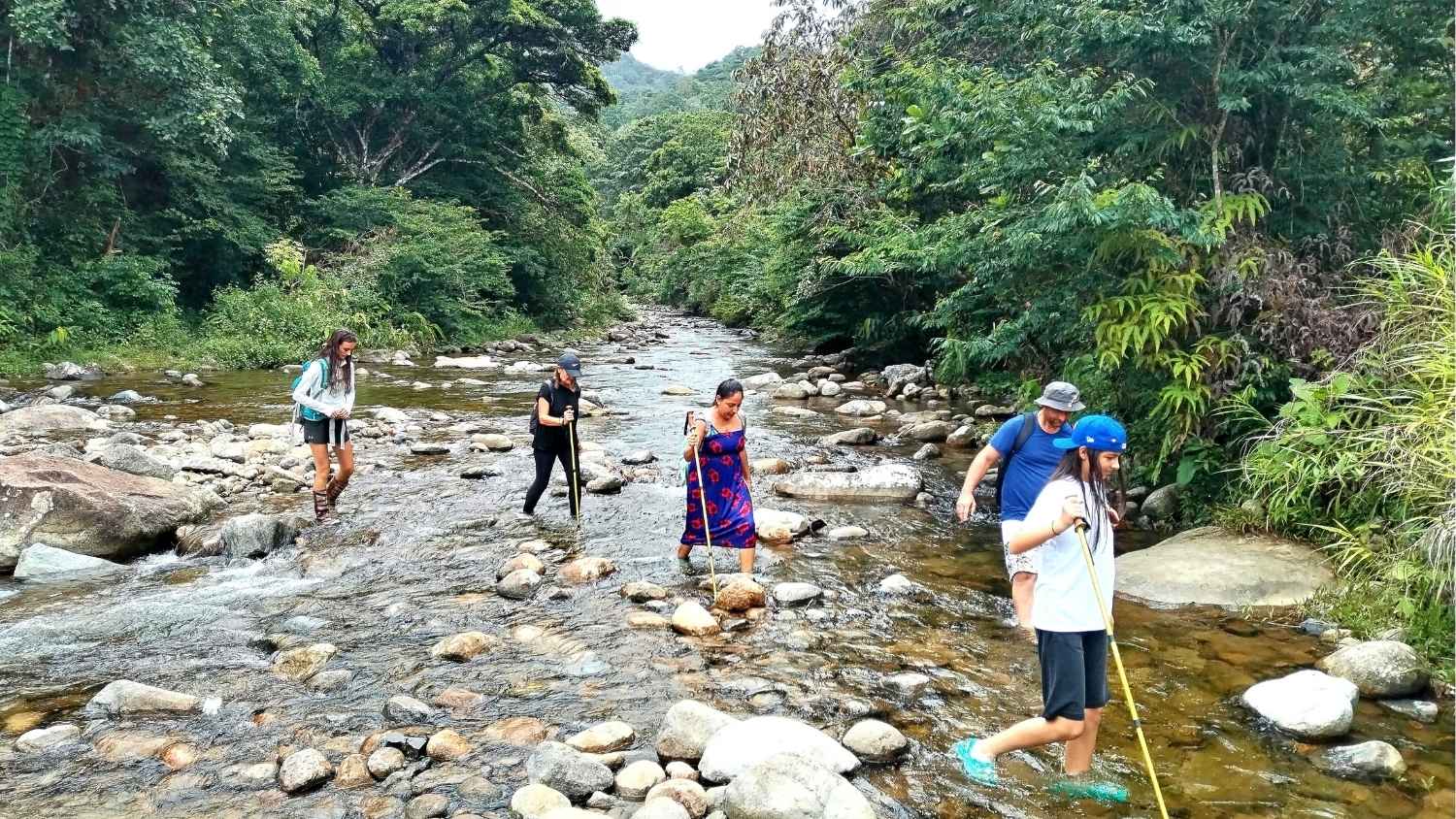 Group crossing a rocky riverbed.