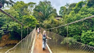 hikers walking on a suspension bridge surrounded by the lush greenery of Santa Fe Veraguas