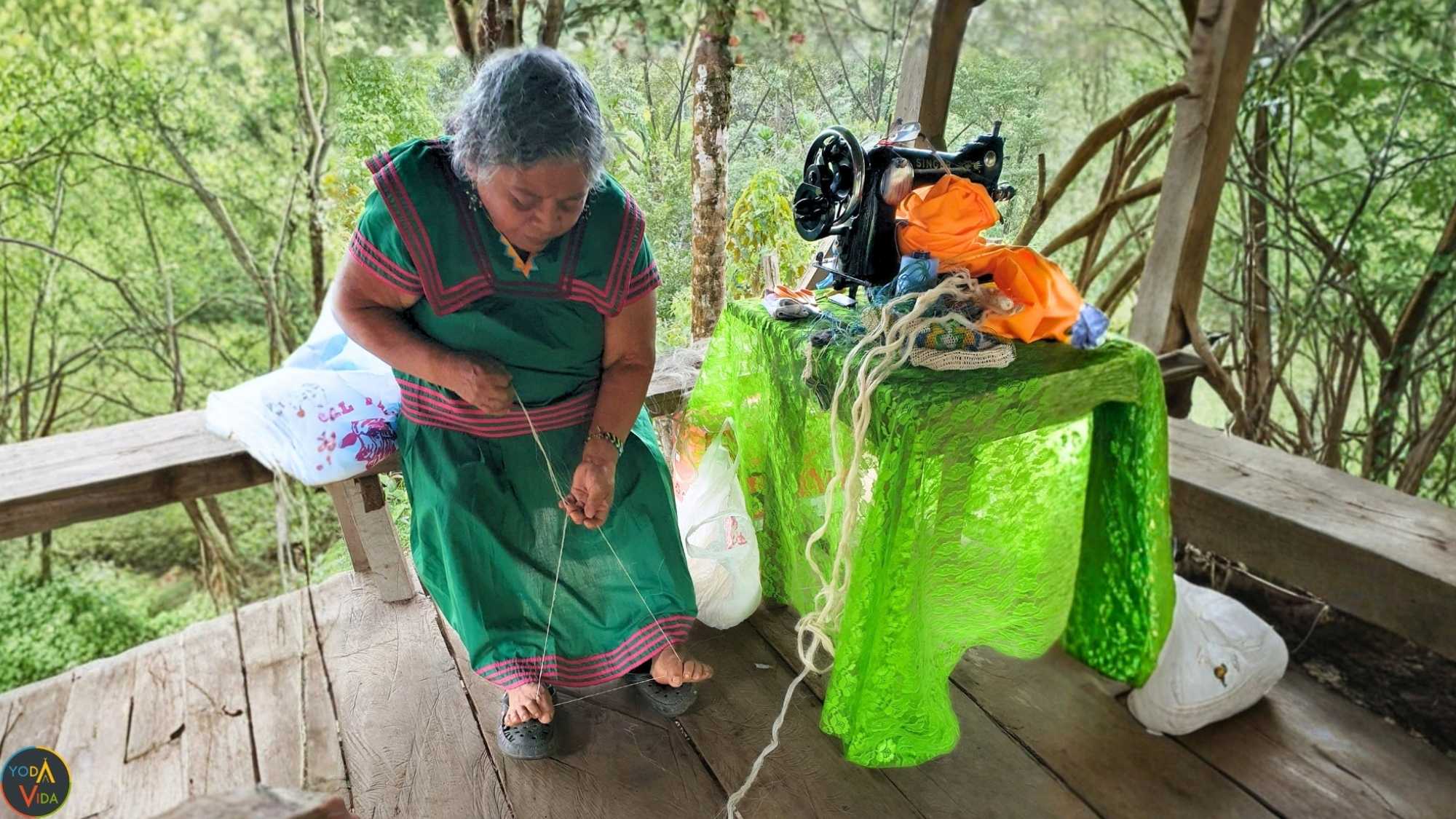 Elderly indigenous woman sewing outdoors